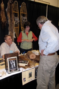 Publisher Bob Serra look over the display of Bob Gilman's book––Bear Tales & Trapline Trails.